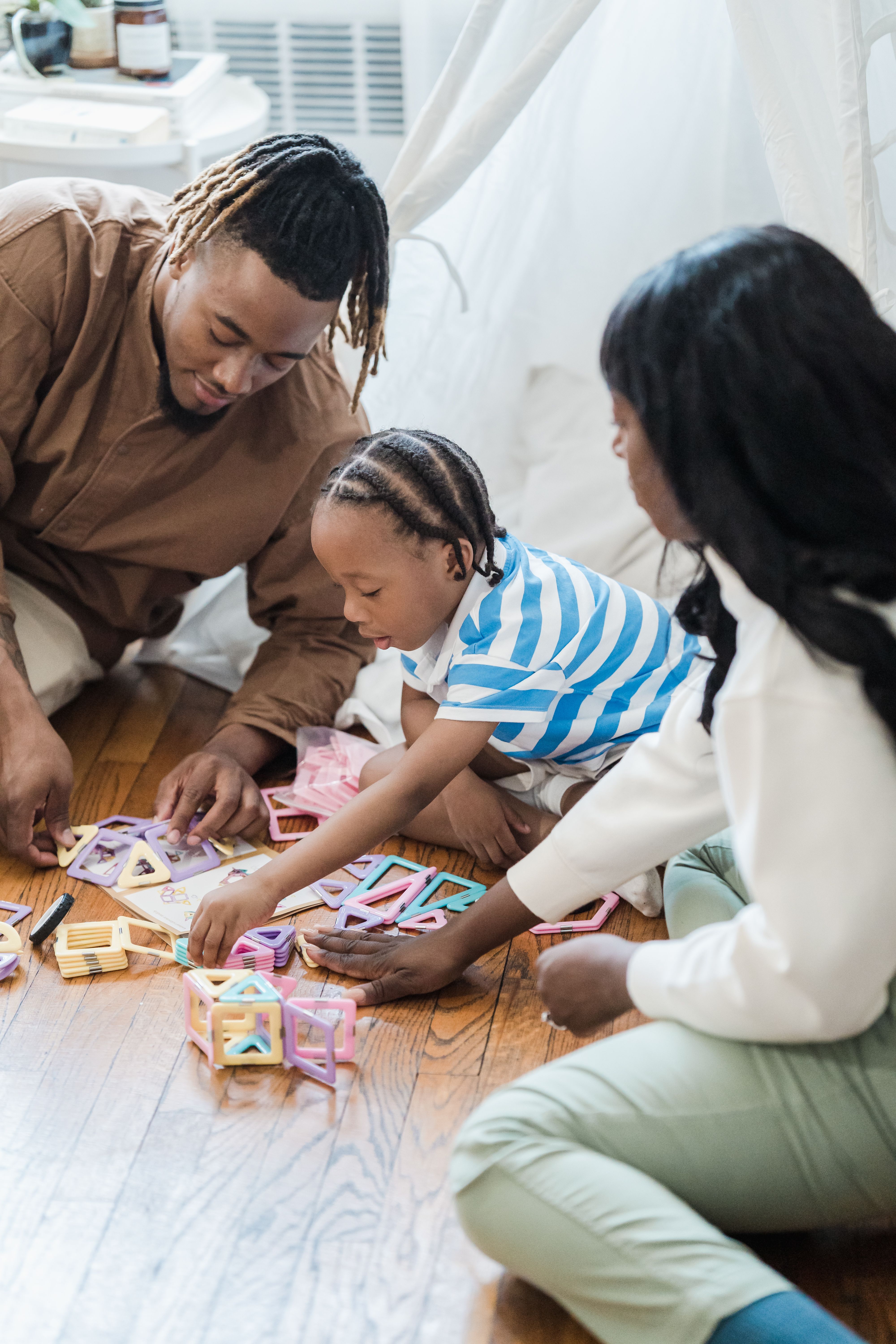 Parents and their child playing together on the floor at home